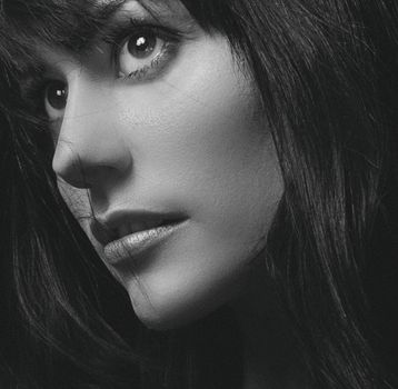 Close-up black and white portrait of a woman's face with expressive eyes.