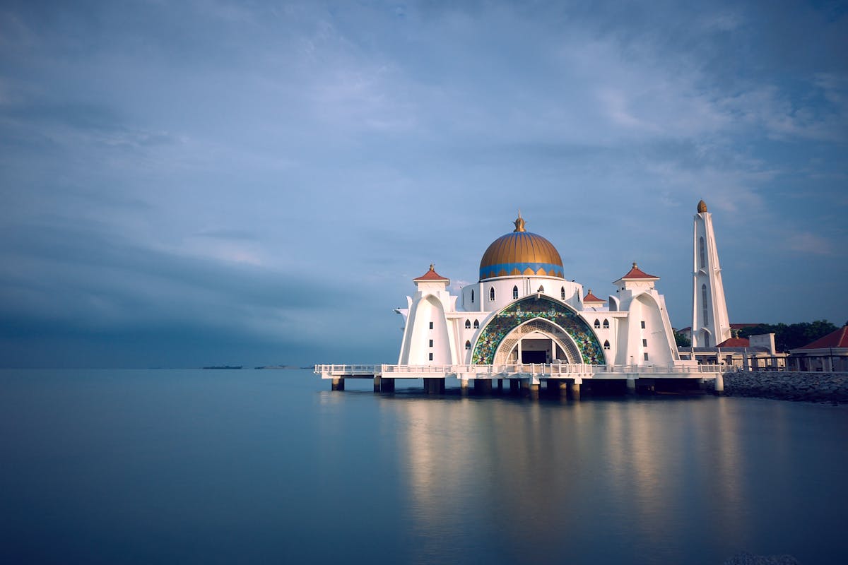 White and Brown Mosque Beside Body of Water