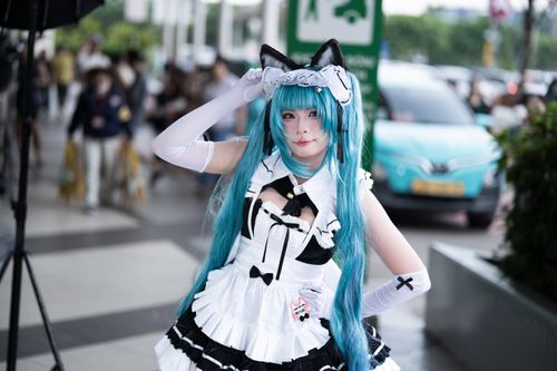 Free A woman in anime cosplay with blue hair and a cat-ear headdress poses outside. Stock Photo