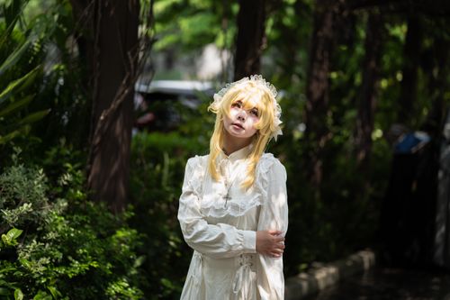Free A person dressed in Gothic Lolita fashion outdoors, surrounded by lush greenery. Stock Photo