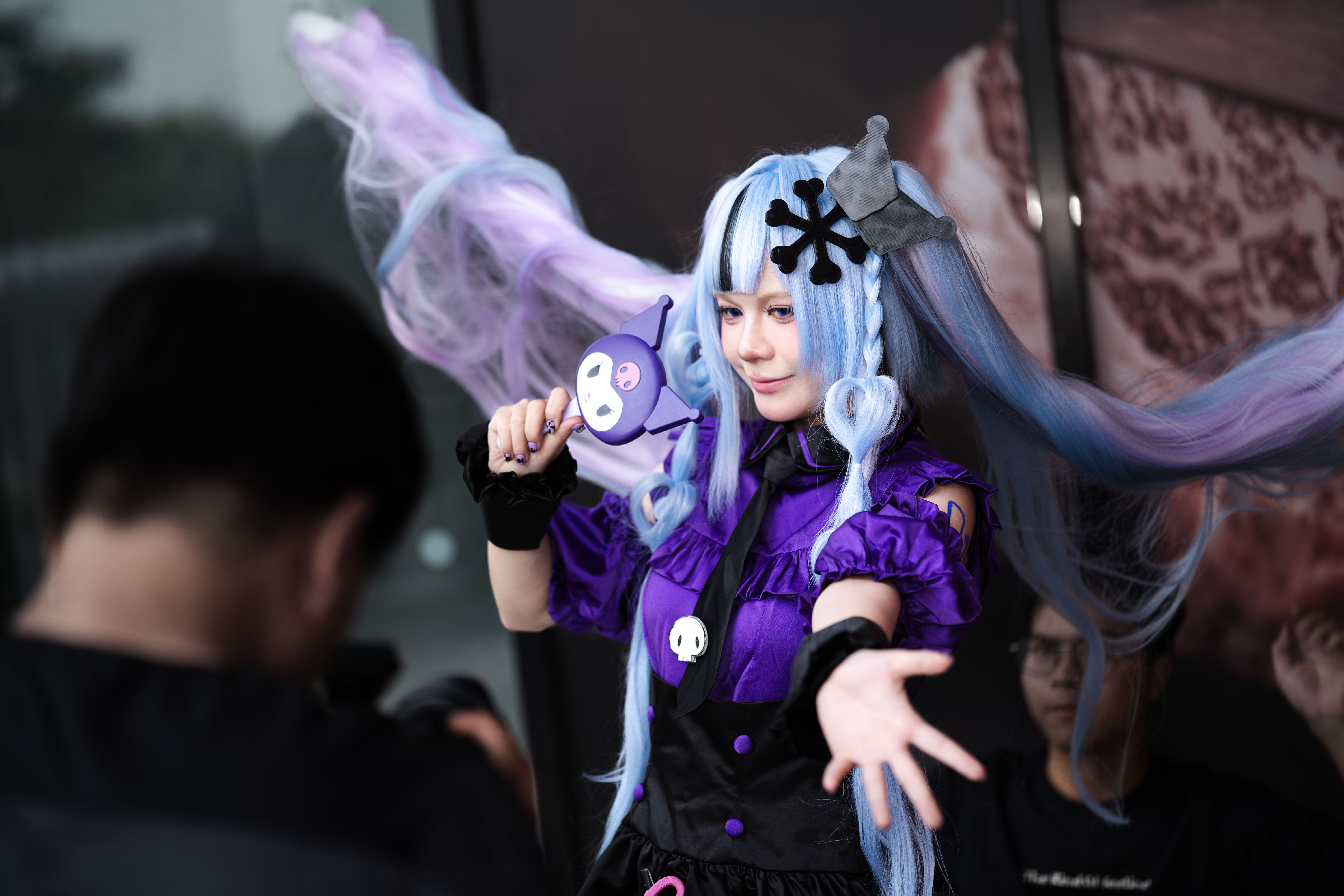 Colorful cosplay of an anime character with lavender hair and purple costume.