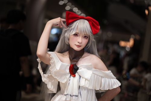 Free Cosplayer in white dress with red bow, posing confidently indoors. Stock Photo