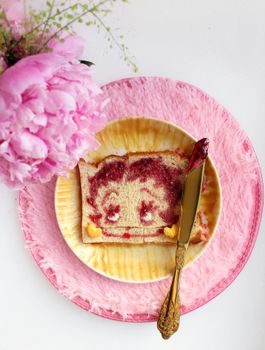 Creative bread with face design using jam, styled with pink decor.