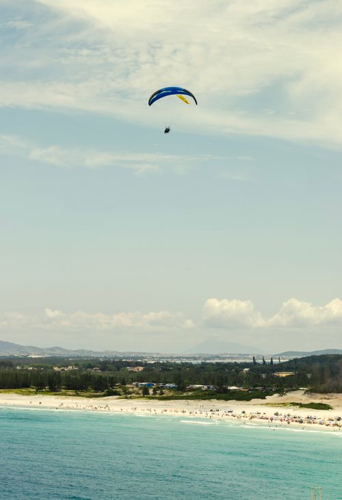 Free Aerial view of a paraglider soaring over the beach in Arraial do Cabo, Brazil on a sunny day. Stock Photo