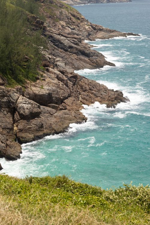 Free Explore the breathtaking rocky coastline with vibrant turquoise waves crashing on the cliffs. Stock Photo