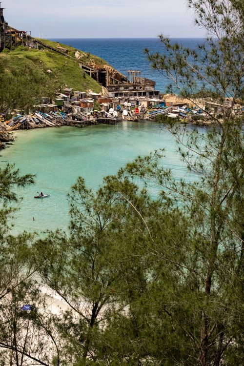 Free Scenic view of a turquoise cove surrounded by lush greenery in Arraial do Cabo, Brazil. Stock Photo