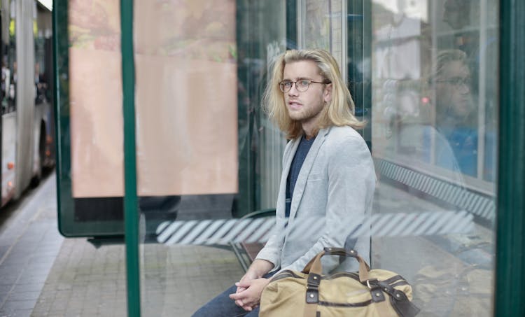 Man Sitting On Waiting Shed