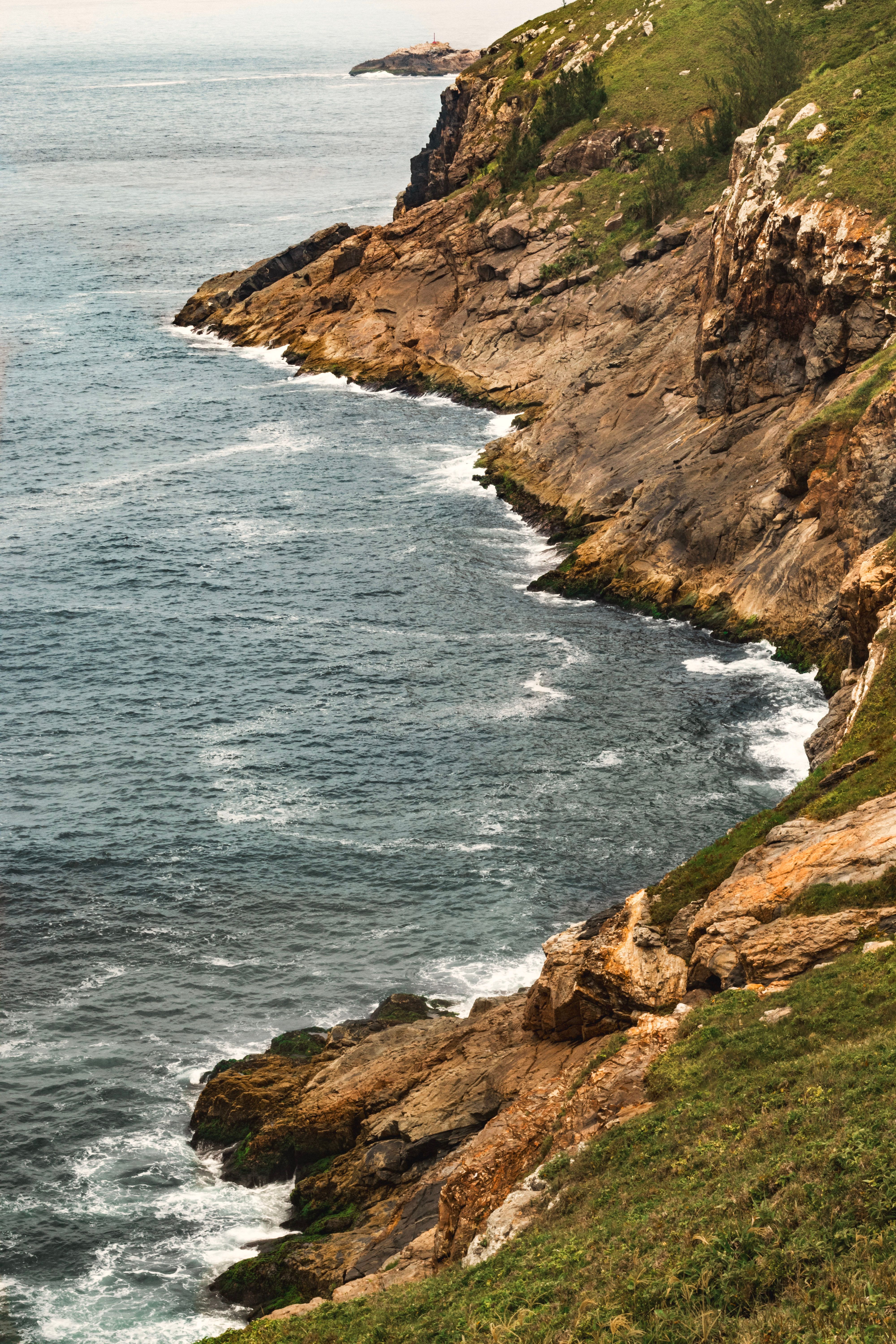Vista deslumbrante de um litoral rochoso no Brasil, exibindo as ondas do Oceano Atlântico.