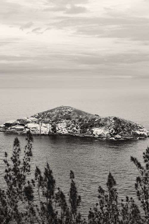 Free Monochrome image of an isolated rocky island with ocean views. Stock Photo