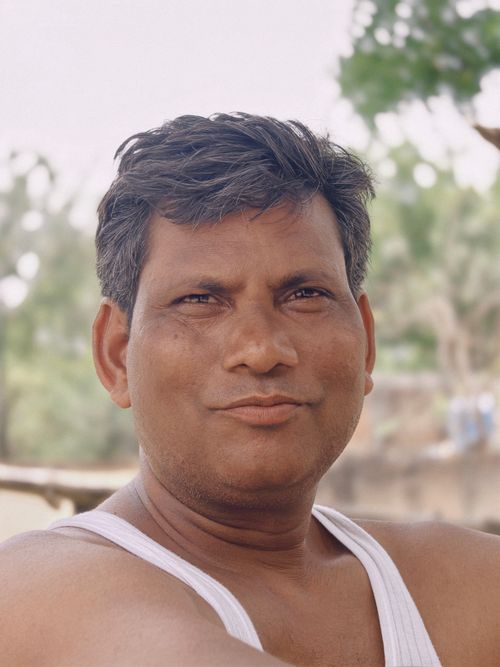 Free Close-up portrait of a man outdoors in a casual white tank top with a natural background. Stock Photo