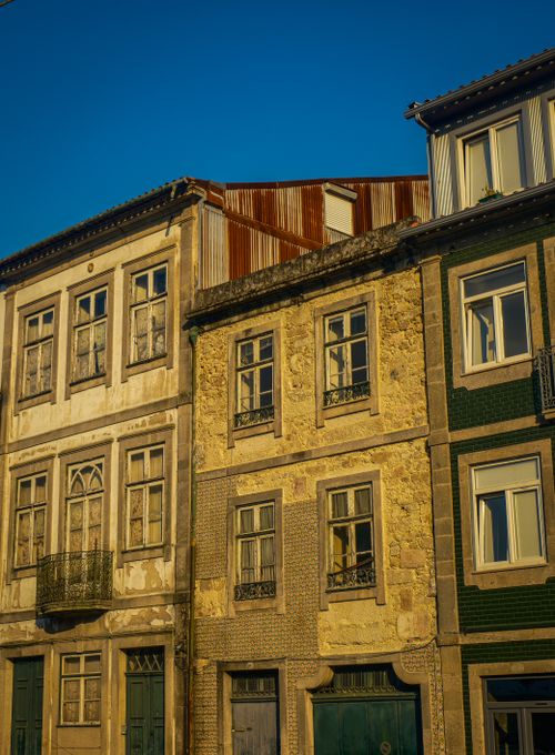 Free Colorful European townhouse facade with rustic textures in warm evening light. Stock Photo