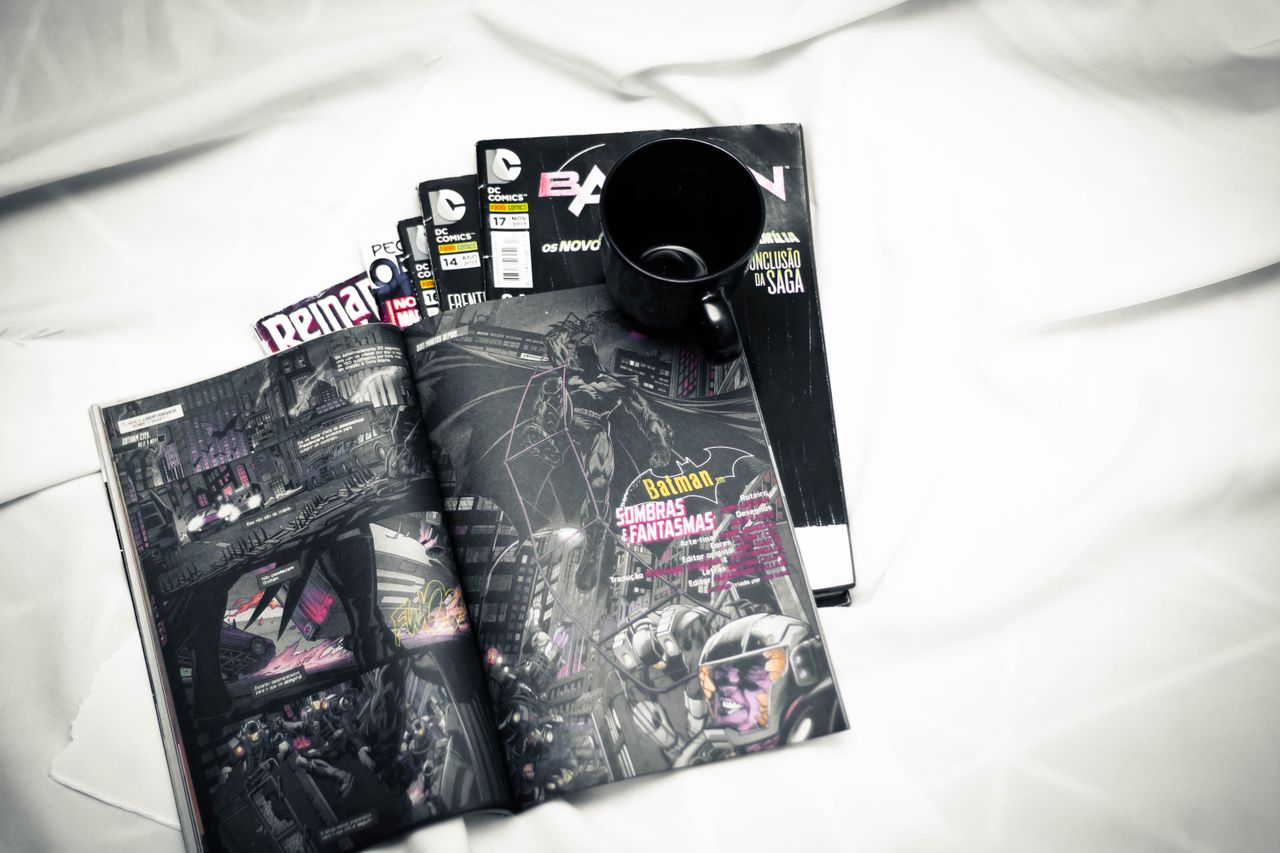 open comic book and mug resting on a bed for a cozy reading vibe