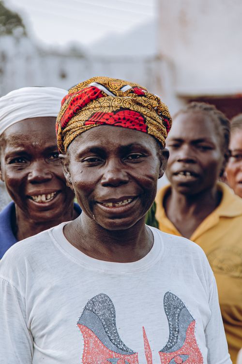 Free Group of smiling African women in colorful traditional clothing outdoors. Stock Photo