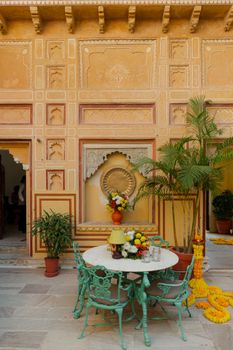 Beautiful courtyard with traditional Indian decor, featuring a table set with floral arrangements.