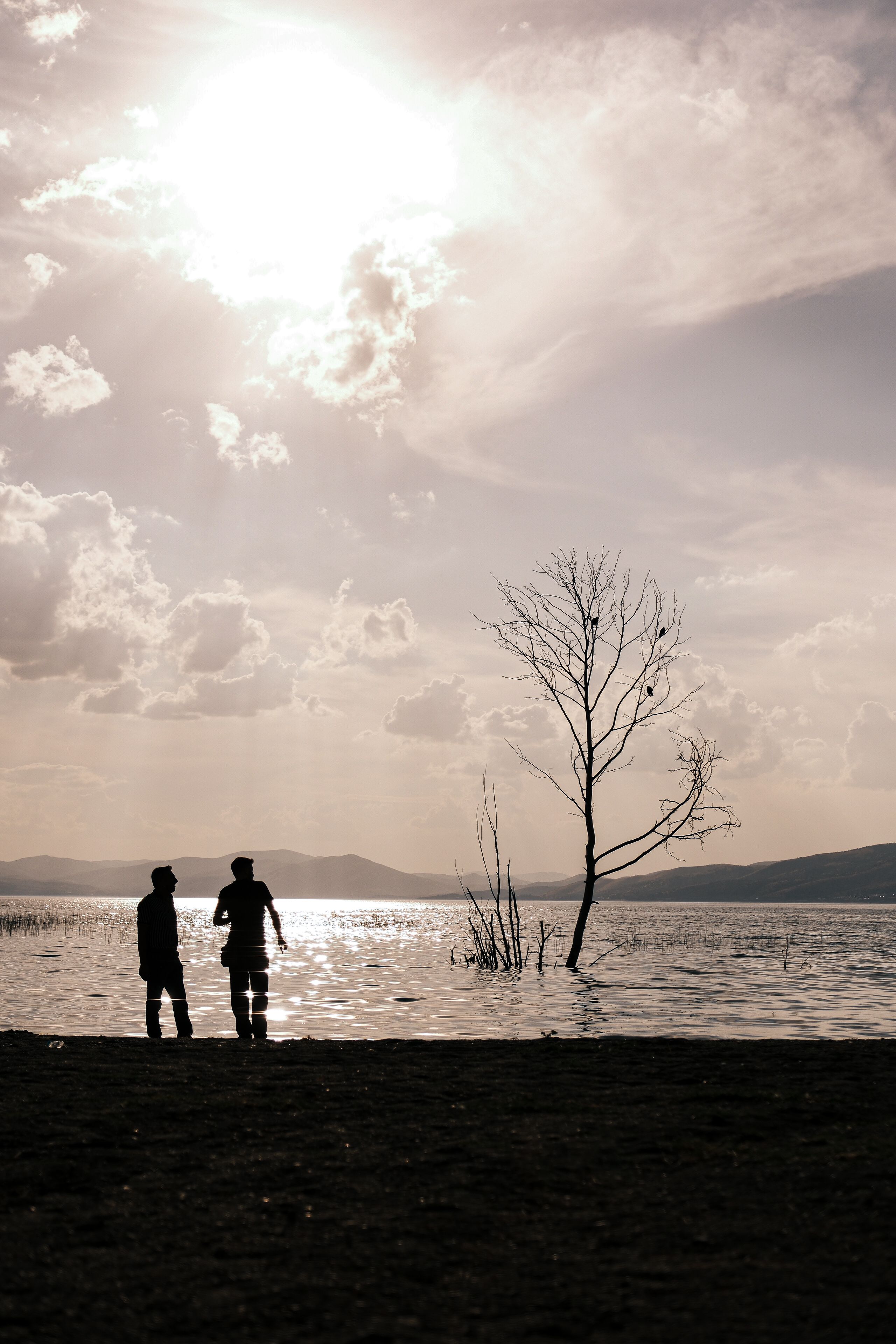 Silhouette Di Due Persone In Riva A Un Lago Tranquillo Al Tramonto ...