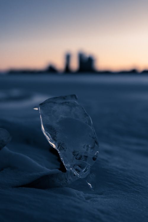 Free A detailed shot of ice against a blurred winter sunset skyline. Stock Photo
