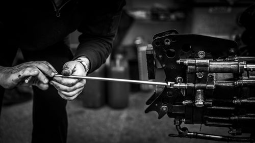 Free Mechanic's hands working on an engine with a tool in black and white. Stock Photo