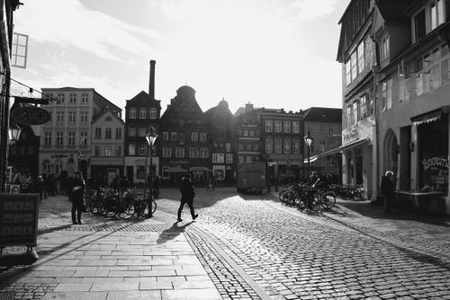 Free Black and white photo of a historic market square in Lüneburg, Germany with bicycles and cobblestone streets. Stock Photo