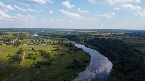 Free Scenic aerial view of a winding river through the lush countryside near Rzhev, Russia under a clear summer sky. Stock Photo