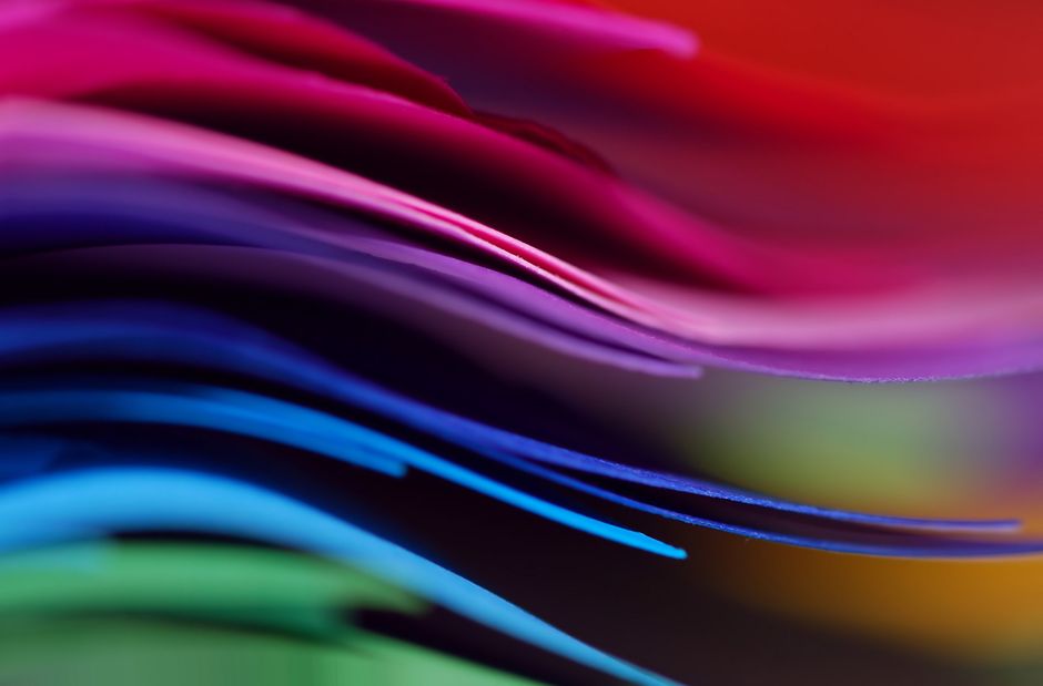 Dynamic close-up of layered colorful paper creating a rainbow effect.