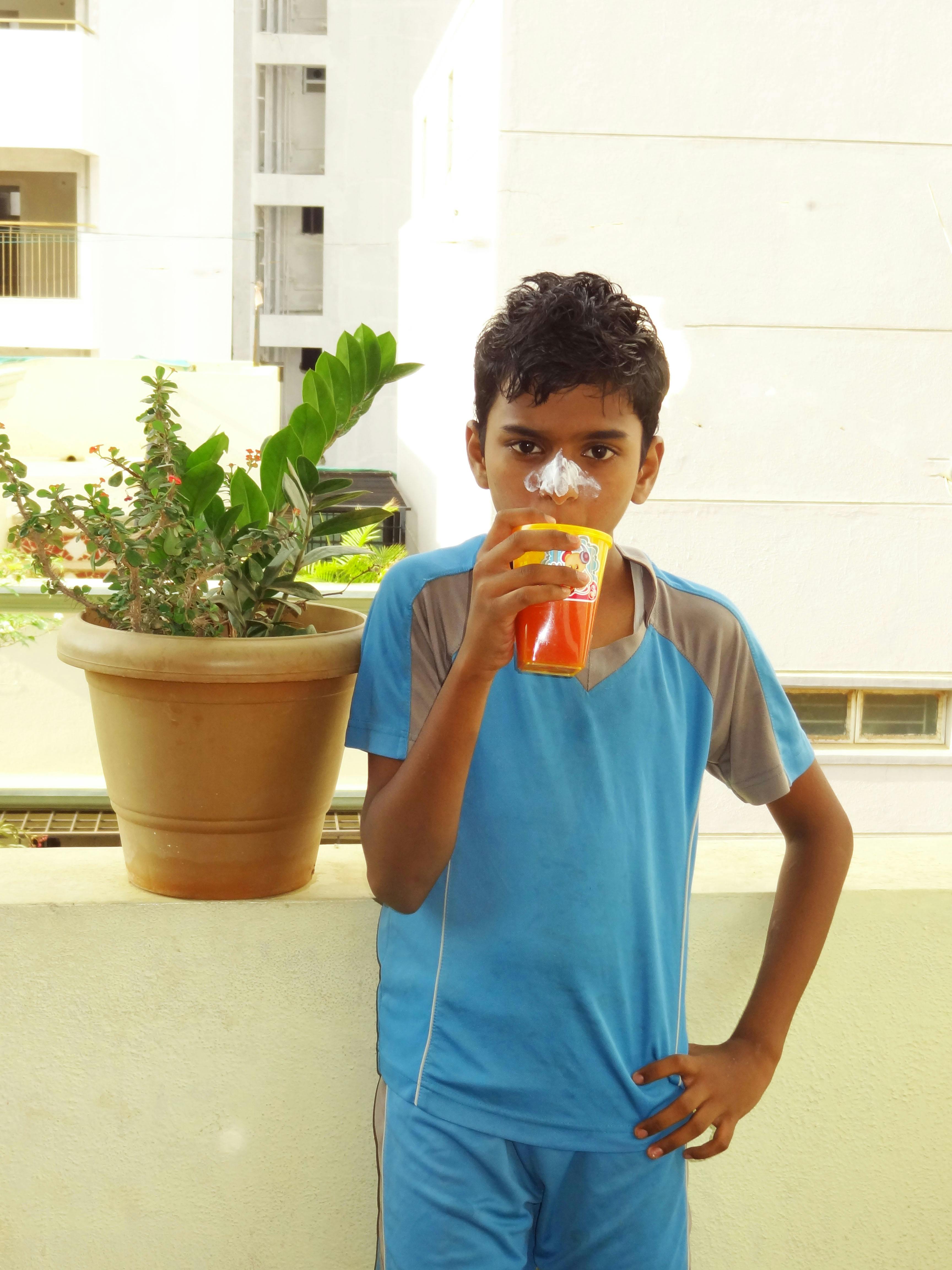 Free stock photo of boy drinking juice, boy with juice cup, cricketer drinking juice