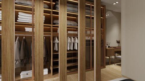 Free Elegant modern walk-in closet with wooden shelves, organized clothing, and soft lighting. Stock Photo