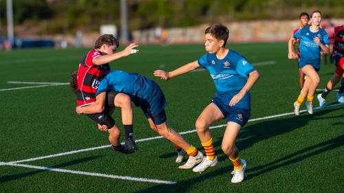 Free Young rugby players in an intense match tackling on a grass field. Stock Photo