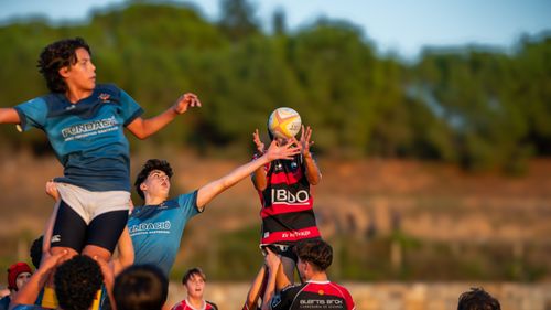 Free Dynamic action shot capturing young rugby players leaping for the ball during a match. Stock Photo