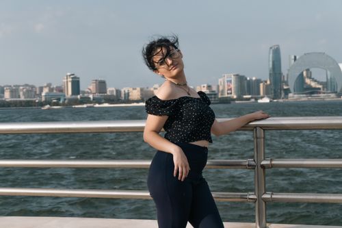 Free Young woman on Baku promenade with city and sea view. Stock Photo