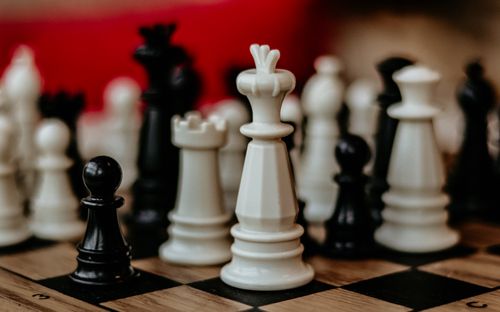 Free Dynamic close-up of black and white chess pieces on a chessboard. Stock Photo