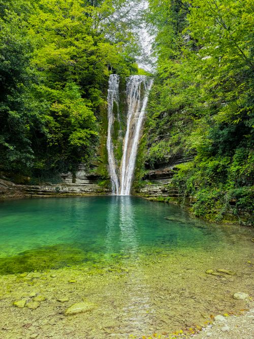 Free Idyllic waterfall cascading into a tranquil pool surrounded by lush greenery in Sinop, Türkiye. Stock Photo