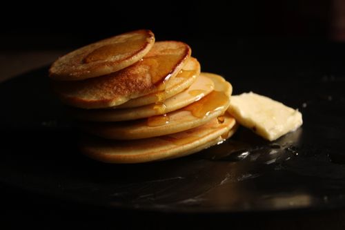 Free Golden brown pancakes drizzled with maple syrup and served with a slice of butter. Stock Photo
