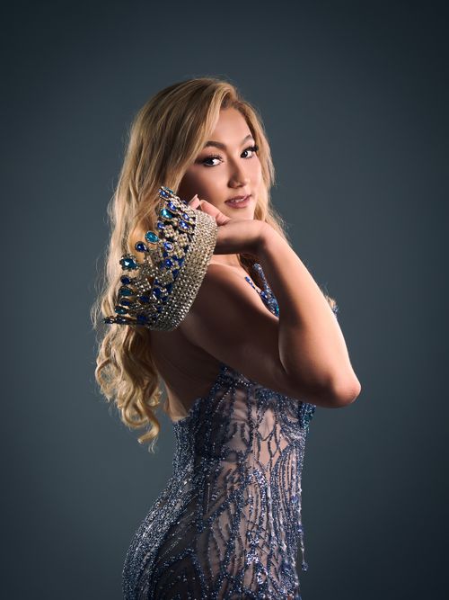 Free Portrait of a beauty queen wearing an elaborate gemstone crown and a sequined dress, exuding elegance. Stock Photo