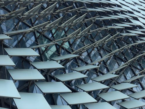 Free Close-up of a modern building facade with a unique geometric design pattern. Stock Photo