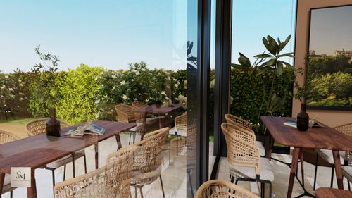 Free Elegant outdoor cafe setting with rattan chairs and lush greenery. Stock Photo
