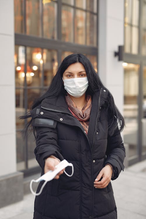 Woman in Black Leather Jacket Wearing White Mask