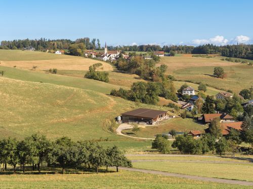 Free Scenic view of a rural village with fields, church, and houses on a sunny day. Stock Photo