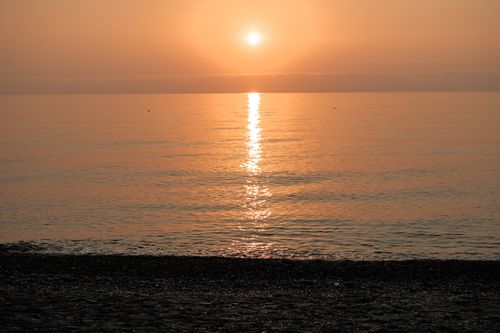 Free Serene sunset over calm ocean waters with golden reflections and a clear horizon. Stock Photo