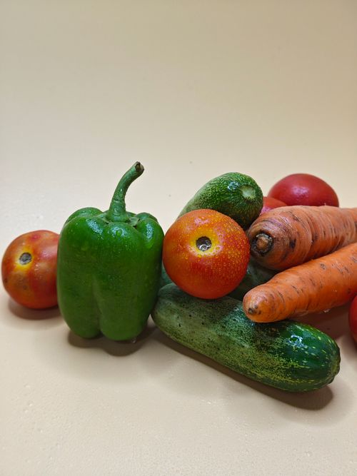 Free A vibrant assortment of fresh vegetables including bell pepper, tomatoes, cucumbers, and carrots. Stock Photo