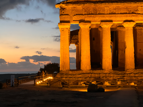 Free Lit Greek temple at twilight in Sicily, Italy, showcasing historic architecture. Stock Photo