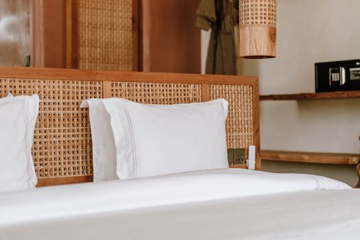 Elegant boutique hotel room featuring a rattan headboard and soft linens in Jambiani, Tanzania.