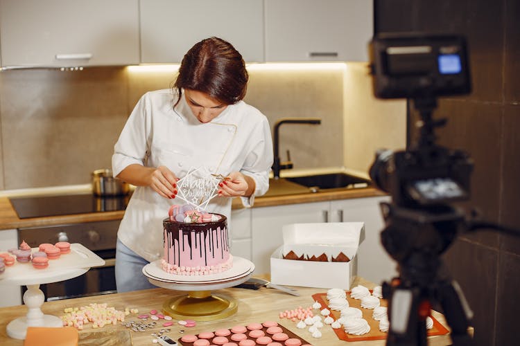 Woman In White Shirt Decorating Cake