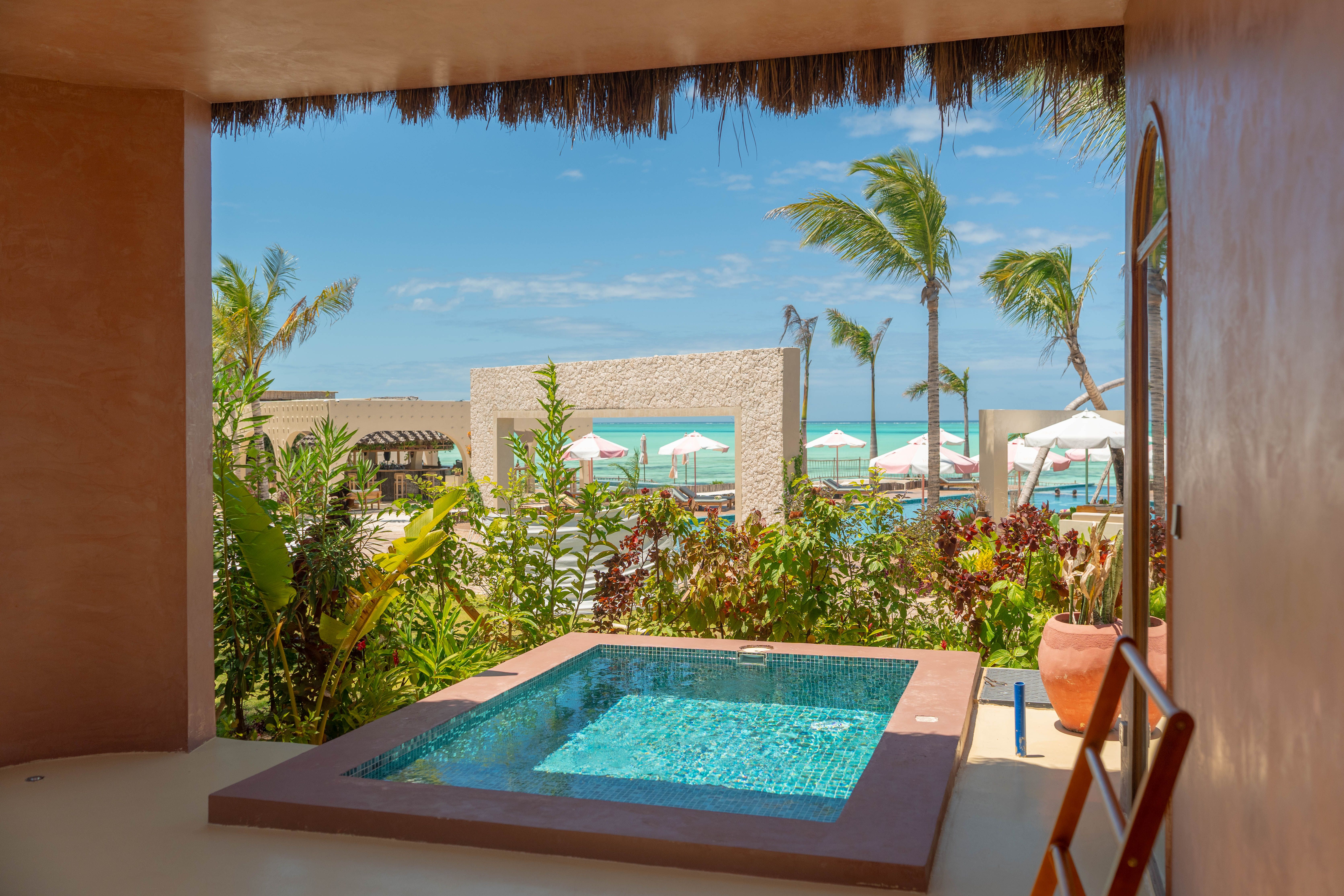 Private villa pool at a Zanzibar beach resort in Jambiani looking out to palm trees and the ocean