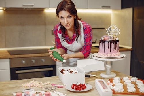 Free Woman in Red Checked Shirt Icing a Cake Stock Photo