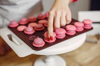 Woman placing shells of macaroons on top
