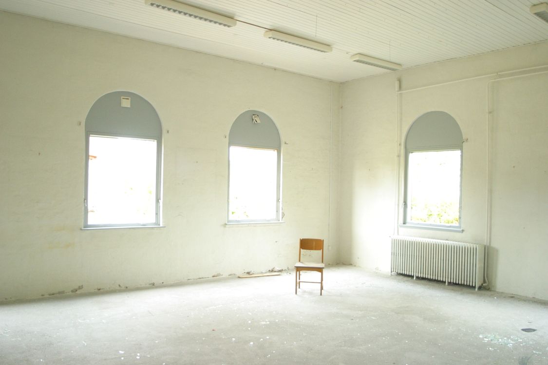 Empty chair in a bare room representing an unresponsive spouse in a divorce case