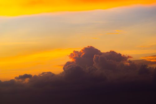 Free A vibrant orange sunset with dramatic dark clouds, creating a stunning contrast in the evening sky. Stock Photo