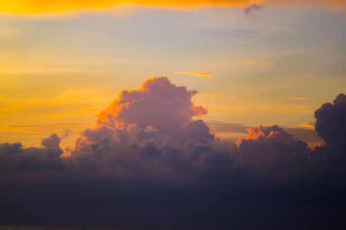 Free A beautiful sunset with vibrant clouds illuminating the sky in warm hues, creating a dramatic and serene atmosphere. Stock Photo