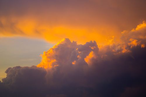 Free Majestic clouds during sunset with vibrant orange and blue hues creating a dramatic sky view. Stock Photo