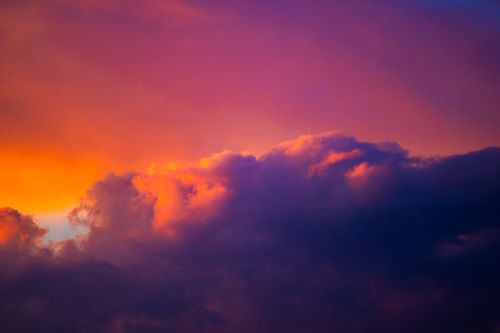 Free A beautiful and vivid capture of sunset clouds in vibrant hues of orange and purple. Stock Photo
